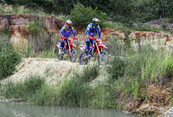 Honda CRF Enduro Madness dirt bike fleet parked on a hilltop with blue sky